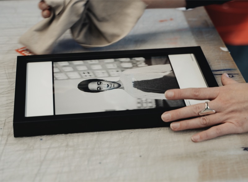 Hand-finishing a framed art print in the studio